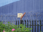 leads to a dead end, with razor wire and a warning sign