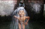 Child taking bath in water spout